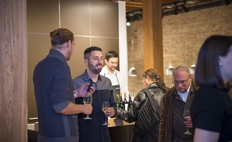Guests chatting and enjoying wine at the opening reception of “A Cast of Things,” an exhibition in the showroom by architecture firm The Los Angeles Design Group.